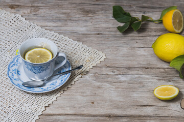 antique tea cup with lemons and wooden background
