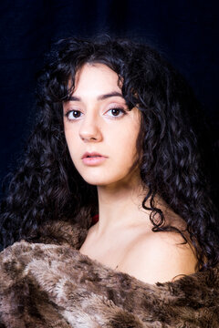 Beautiful woman  with a fur blanket on black background