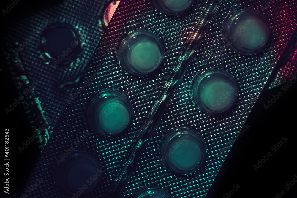 Poster pills or drugs in a package under neon light on a dark background pattern for design..
