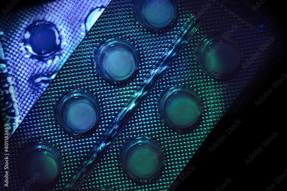 Poster pills or drugs in a package under neon light on a dark background pattern for design..