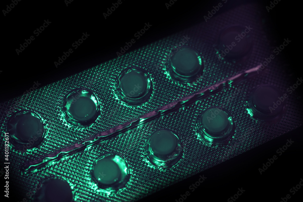 Poster pills or drugs in a package under neon light on a dark background pattern for design..