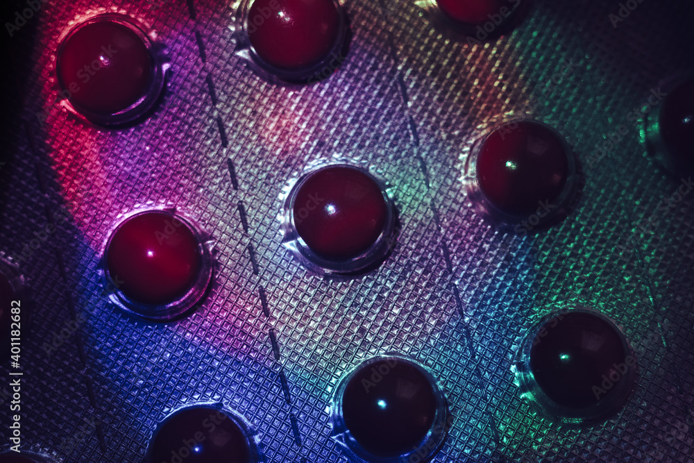 Poster Pills or drugs in a package under neon light on a dark background pattern for design..