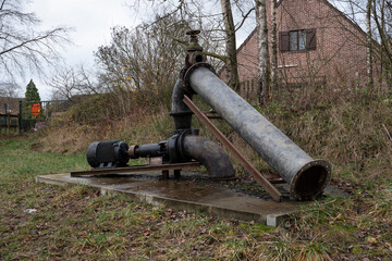 Old pump that pumps rain water in a forest in Stekene, Belgium