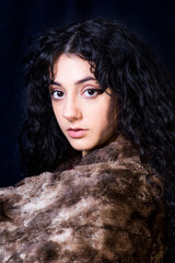 Beautiful woman  with a fur blanket on black background