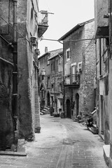 Black and white photo of narrow curved street in ancient italian town
