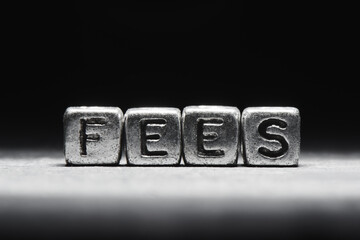 Fees concept. 3d inscription on metal cubes on a gray black background isolated
