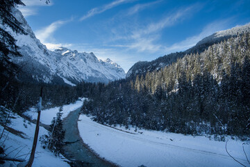 un paesaggio invernale di montagna, la prima neve in montagna crea un'effetto magico nel paesaggio che si trasorma, un corso d'acqua con effetto seta