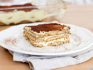 Slice of tiramisu in a white dish. Vegan dessert 