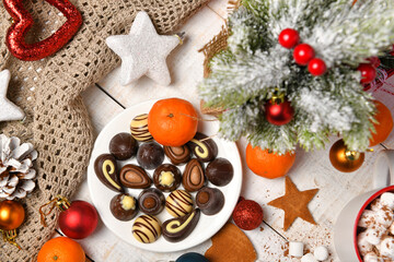 Fototapeta na wymiar sweet food top view background for merry christmas or new year holiday decoration - chocolate candies, tangerines, cookies, marshmallow and cocoa latte on white wood