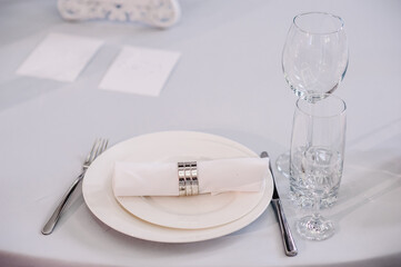 Serving, setting table. Plate and silverware cutlery linen white napkin. Wedding table decoration. Artwork. side view. Close up.