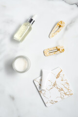 Hair care cosmetics set and feminine accessories on the marble table. Flat lay, top view.