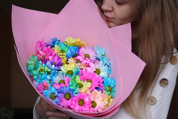 Close up - Woman holding colorful rainbow bouquet in pink packaging