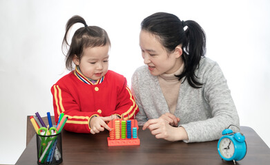 Young mother teaches her daughter to arithmetic