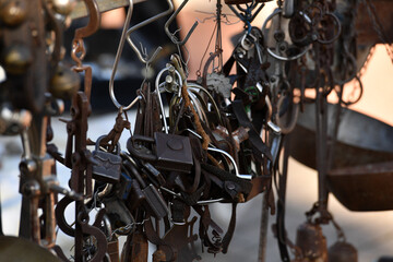 Rusty padlocks and many other small, old things in a row on a second hand market in Spain.