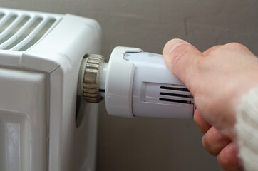 The woman is changing temperature of radiator