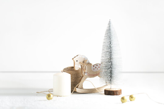 Winter Christmas tree composition with a wooden toy and candle background banner with silver and golden details on the white backdrop