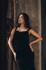 Fototapeta na wymiar Fashion photoshooting in a photo studio of a beautiful girl in a black dress