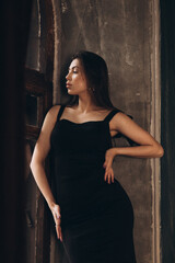 Fototapeta na wymiar Fashion photoshooting in a photo studio of a beautiful girl in a black dress