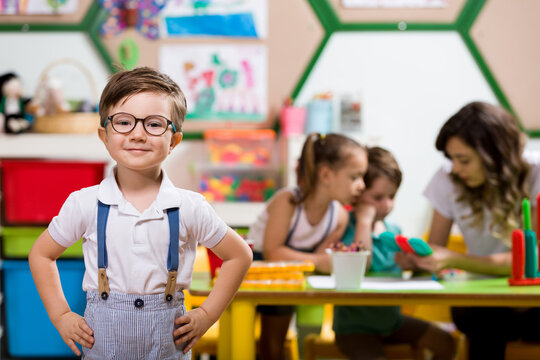Preschooler posing at camera in classroom.