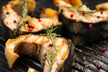 Sturgeon steaks on the grill with spices and herbs.