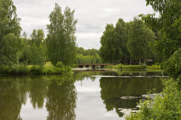 Fototapeta na wymiar view of a beautiful pond in the Russian Art Park in Kostroma, photo was taken on a cloudy summer day