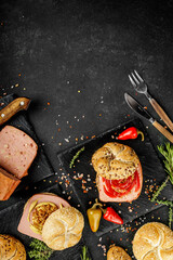 Obraz na płótnie Canvas Flat lay composition of delicious hot dogs and sandwiches with different toppings on the dark background