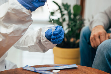 Close up of medical staff hands introducing the nasal swab to the buffer tube to take a nasal...