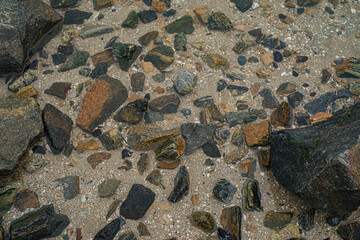 Granite stones under the water. Pebbles texture in the sea