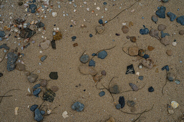 Stones abstraction at the sand. Pebbles near the sea.After the storm