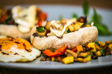 Mushroom stuffed with fresh vegetable mixture and egg. The food in the restaurant. Food styling and restaurant meal serving.