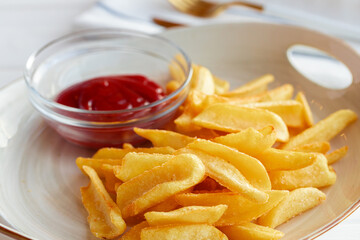 French fries potatoes in plate with sauce on wooden table