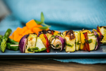 Grilled skewer with vegetables and mushrooms on plate with asparagus. The food in the restaurant. Food styling and restaurant meal serving.