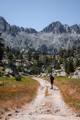 Obraz premium Senderista caminando por un camino en el parque nacional de aiguestortes con vistas a las montañas 