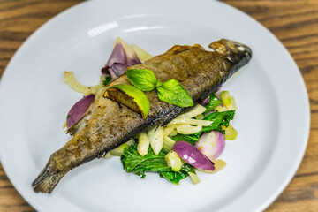 Grilled trout on roasted vegetables. The food in the restaurant. Food styling and restaurant meal serving.