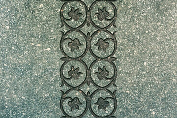 Ornamental print on the granite surface. Vintage ornament on the stone. Embossed drawing. Close-up. Stone texture. Pattern on the stone. Embossed pattern. Wallpaper. Tile. Close-up of seamless texture