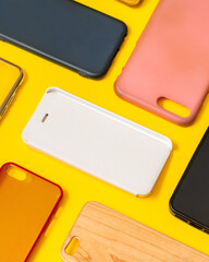 Pile of multicolored plastic back covers for mobile phone. Choice of smart phone protector accessories on black background. A lot of silicone phone backs or skins next to each other