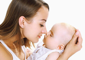 Portrait of happy mother holding on hands and kissing her little sleeping baby on a white background