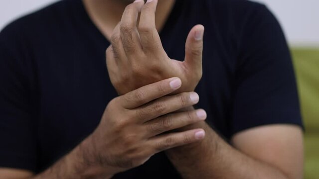 Close up male hand get hurt and pain in hand, wrist. Symptom office syndrome. He has symptom stress in his hand stiffness causing inconvenience.