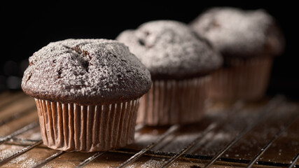 Three muffins sprinkled with powdered sugar