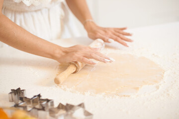 Girl rolls out dough for New Year's cookies. High quality photo
