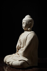 White Clay Buddha on black background – spa composition for relax and meditation