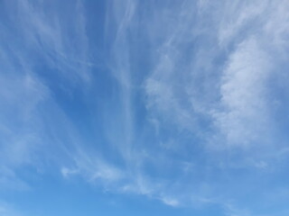 Obraz premium Dark blue sky, on a hot summer morning with white clouds, cirrus are tiny streaks scattered around. The calm sky with little light indicates a good day to relax.Sky nature background 