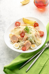 Salad with baked salmon. A large portion of salad with red fish, fresh vegetables, eggs, cherry tomatoes and lemon.