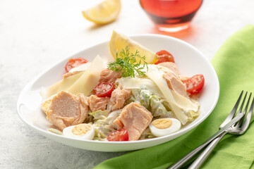 Salad with baked salmon. A large portion of salad with red fish, fresh vegetables, eggs, cherry tomatoes and lemon.