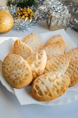 Biscuits in the form of cones on a white plate near the Christmas decorations 