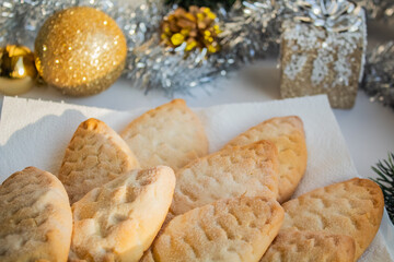 Biscuits in the form of cones on a white plate near the Christmas decorations 