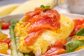 Fried eggs with green asparagus and salmon, cherry tomatoes and fresh spinach.