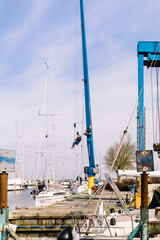 Fototapeta na wymiar Preparing sailboats for the new season in marina of Hindeloopen, Netherlands