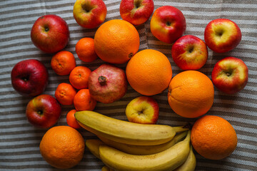Many different fresh fruits are on the table on a mottled light canvas, top view