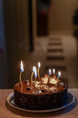 Birthday chocolate cake with candles on the empty festive table. Selective focus. LOW DOF. 